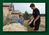 Adaś and Kuba demolishing a heap of sand.